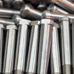 Shiny steel parts background. Regular industrial metal production pattern with selective focus.High precision steel automotive parts manufacturing by innovative CNC machining