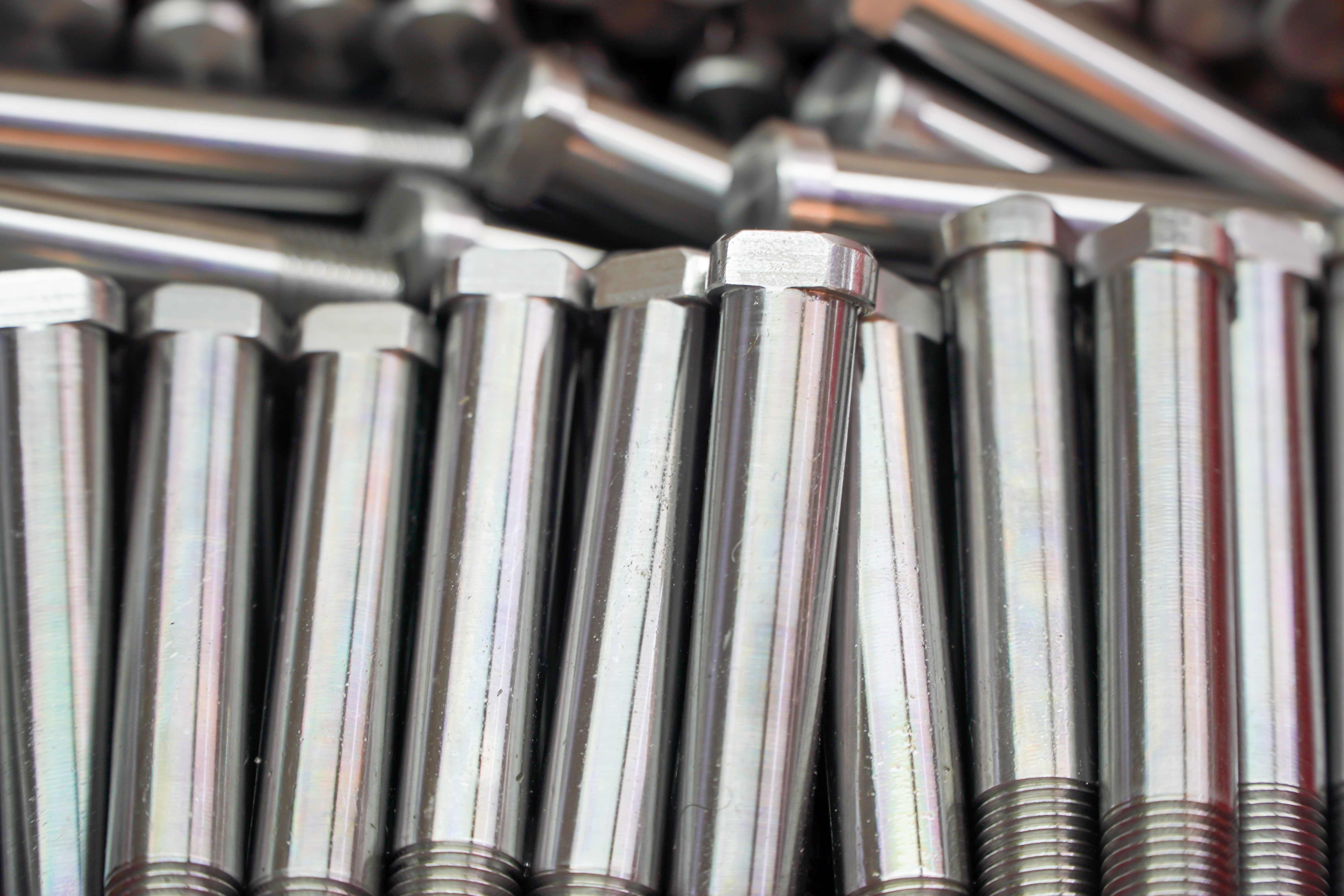 Shiny steel parts background. Regular industrial metal production pattern with selective focus.High precision steel automotive parts manufacturing by innovative CNC machining